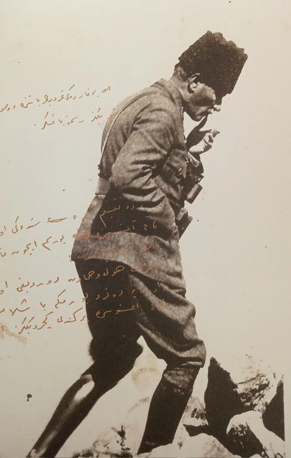 Kalpaklı ve üniformalı Mustafa Kemal Paşa, kayalık bir zeminde öne eğilmiş yürüyor; fotoğrafın sol tarafına Osmanlı Türkçesiyle notlar düşülmüş.